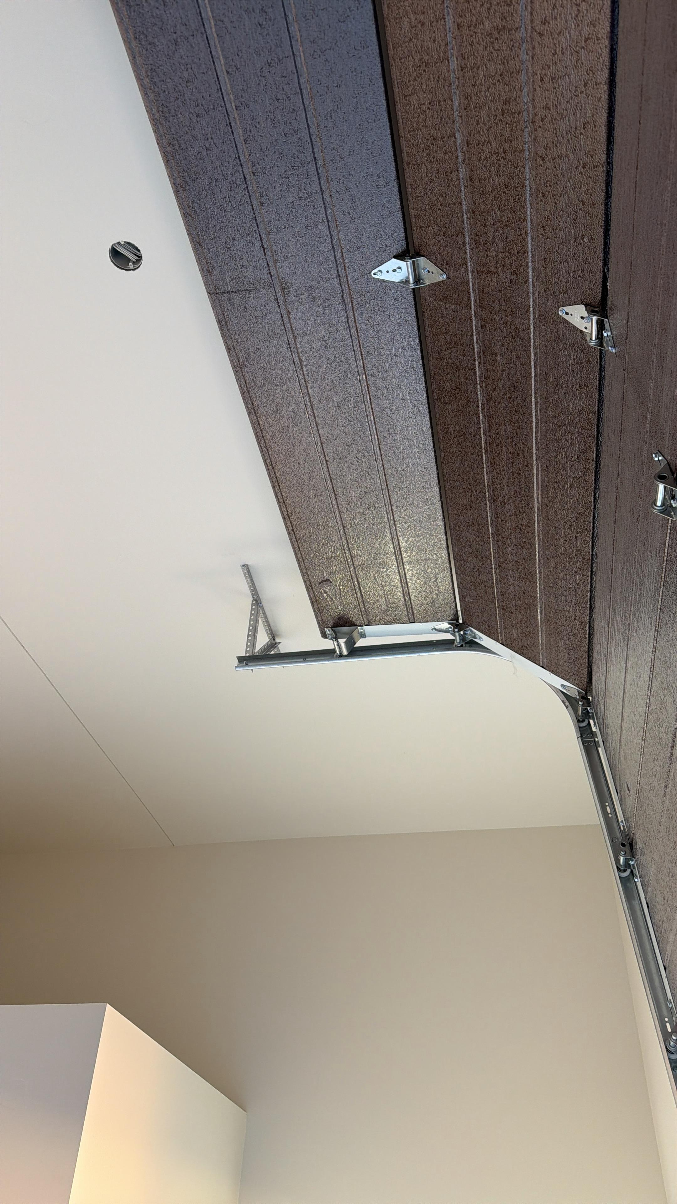 Technician installing a garage door spring during a service call