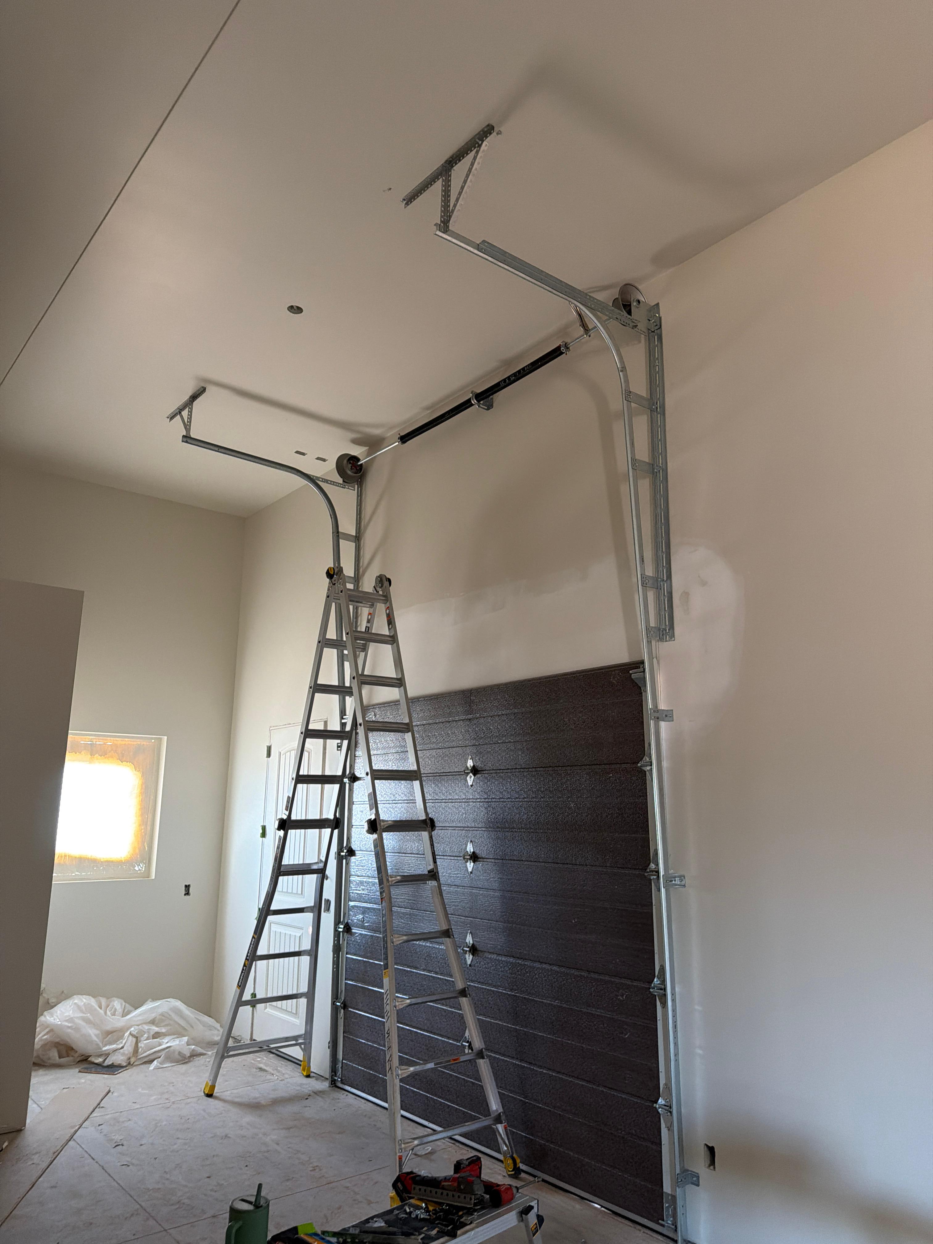 Technician installing a garage door opener spring system