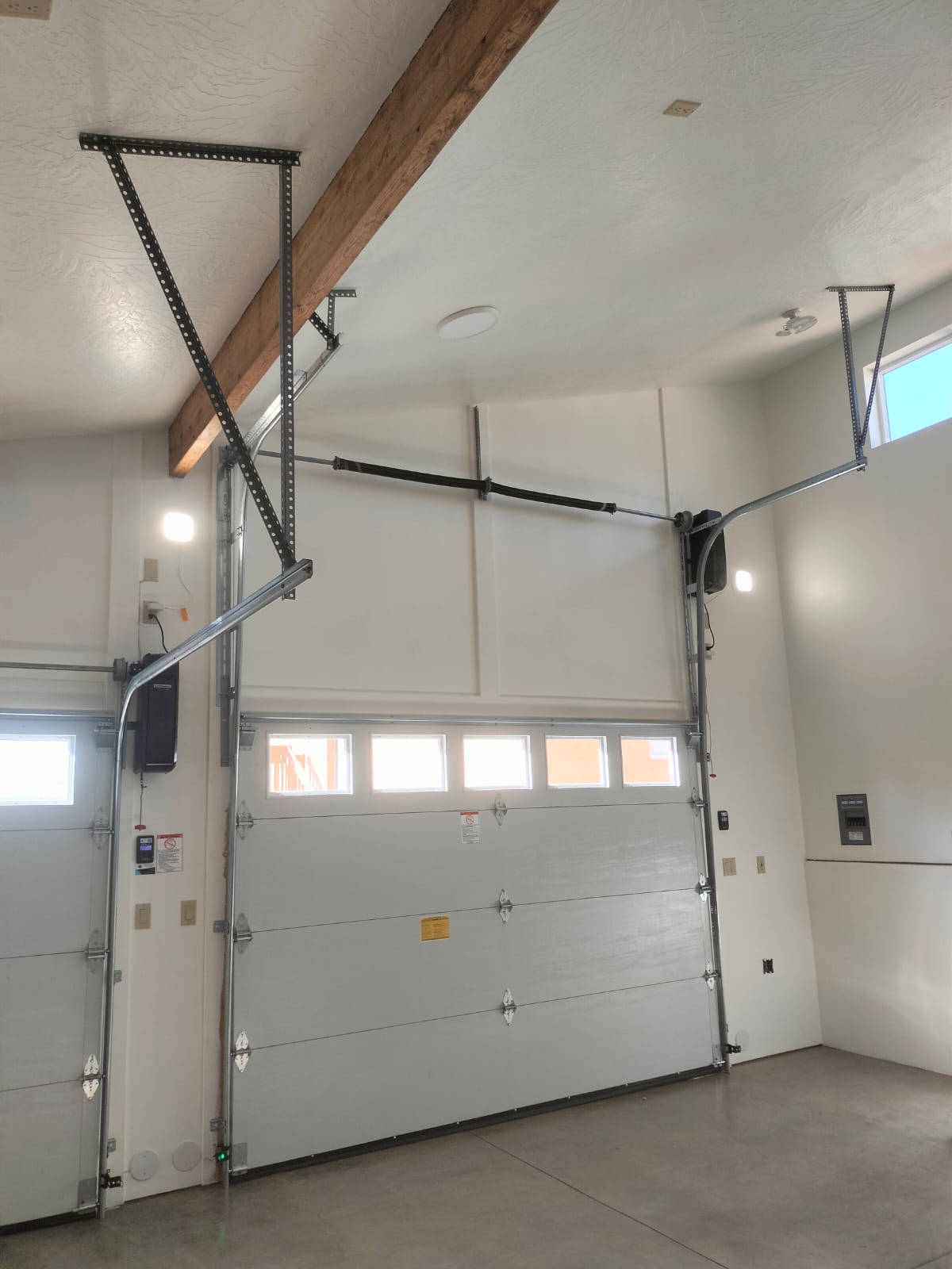 Technician installing a garage door torsion spring system in a Southern Utah home